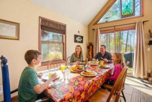 a family sitting around a table eating food at Family-Friendly Home w Hot Tub Fire Pit Games in North Glade