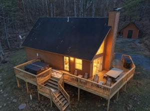 an overhead view of a log cabin with a large deck at Family-Friendly Home w Hot Tub Fire Pit Games in North Glade +42 photos