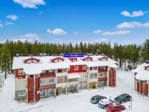 an apartment building with cars parked in the snow at Levi Lumia Home, Moonlight 409 in Levi
