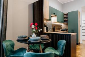 eine Küche mit einem Tisch mit einer Blumenvase in der Unterkunft Lucia in Jarosław + 22 Fotos