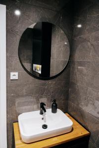 ein Badezimmer mit einem weißen Waschbecken und einem Spiegel in der Unterkunft Lucia in Jarosław