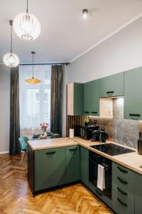 eine Küche mit grünen Schränken und Holzböden in der Unterkunft Lucia in Jarosław
