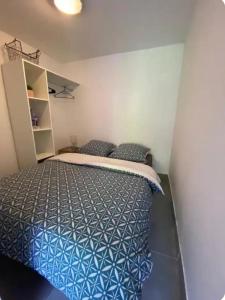 ein Schlafzimmer mit einem Bett mit einer blauen Bettdecke in der Unterkunft Entire apartment in Auxerre in Auxerre