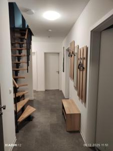 a hallway with a staircase and a wooden bench at Fe-Wo Varenrode in Spelle