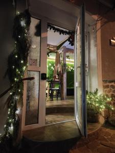 eine offene Tür zu einer Terrasse mit Weihnachtsbeleuchtung in der Unterkunft Hide Hub Guest Apart in Weliko Tarnowo