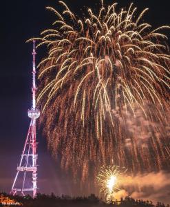 uno spettacolo pirotecnico con una torre televisiva sullo sfondo di Center Tbilisi Apartments a Tbilisi City