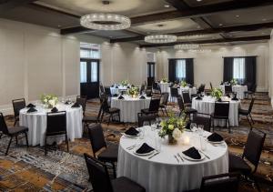 a banquet room with white tables and chairs and chandeliers at The Inn at Patrick Square in Clemson