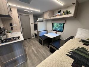 een kleine kamer met een bed en een bureau in een caravan bij Little Foot RV in Klamath