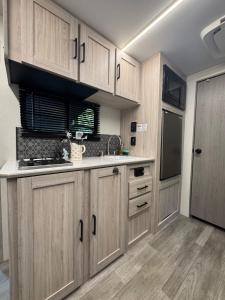 een keuken met houten kasten en een spoelbak bij Little Foot RV in Klamath +5 foto's