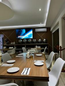 ein Esszimmer mit einem Holztisch und weißen Stühlen in der Unterkunft Hotel Soleil Business Class in León