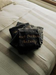 a pair of black pillows sitting on a bed at Sunset Penthouse Antwerp in Antwerp