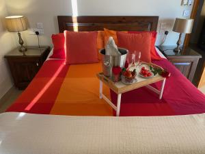 a bed with a colorful bedspread and a table with glasses at Ta’ Giljan B&B Gozo in Xagħra