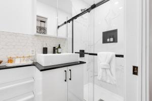 un bagno bianco con lavandino e doccia di Downtown Penthouse 2 Level-4BDRS-8Guests a Montréal