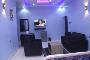 Dreamville Hotel & Resort في أويو: غرفة معيشة مع تلفزيون على الحائط