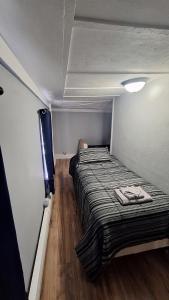 a small bedroom with a bed in a room at Central Apartment, Steps from the Park in Oswego