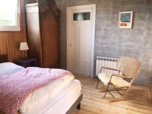 una camera da letto con un letto e una sedia di Maison de campagne au bord de la mer a Fort-Mahon-Plage