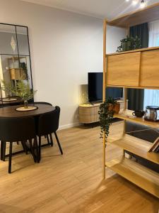 Riga Riverside Escape Lucavsala, Close to City Center في ريغا: غرفة معيشة مع طاولة وغرفة طعام