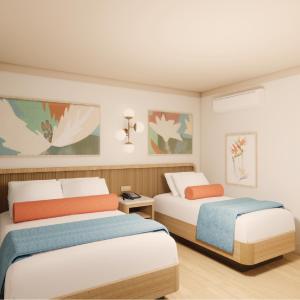 two beds in a hotel room with two beds at Pavilion Hotel in Avalon +13 photos