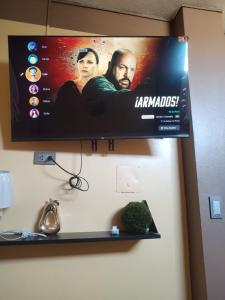 a flat screen tv hanging on a wall at Departamento Moderno y Acogedor con aire acondicionado in Tumbes