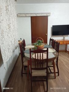 a dining room with a table and chairs and a television at La casita in Medellín