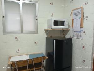 a kitchen with a microwave on top of a refrigerator at La casita in Medellín +4 photos