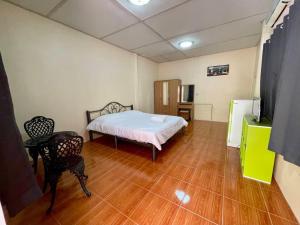 een kamer met een bed en een televisie. bij ไร่ภูตะวัน in Ban Muang Ton Mamuang