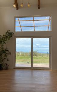 a room with a large window with a view of a field at Casa Cálida entorno natural con vista al Estrecho in Leñadura