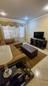 Una sala de estar con un sofá y un piano. en Casa para cuatro adultos, en Asunción