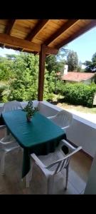 a green table and white chairs on a patio at Das Kleine Nest in Villa General Belgrano