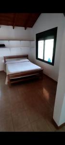 a large room with a bed and a window at Das Kleine Nest in Villa General Belgrano