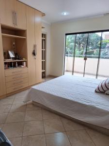 Un dormitorio con una cama grande y una ventana grande. en Casa para cuatro adultos, en Asunción