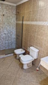 Un baño con dos inodoros y una ducha. en Casa para cuatro adultos, en Asunción 4 fotos más