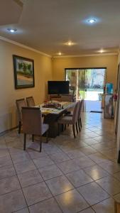 Un comedor con una mesa y sillas y un piano. en Casa para cuatro adultos, en Asunción