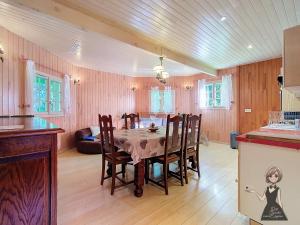 a kitchen and dining room with a table and chairs at Chalet Tulasi, douceur et sérénité à Eysus in Eysus