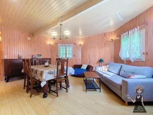 a living room with a couch and a table at Chalet Tulasi, douceur et sérénité à Eysus in Eysus