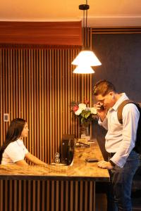 a man and a woman standing at a desk at Neos Hotel Cartagena in Cartagena de Indias