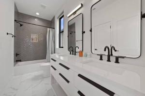un bagno bianco con 2 lavandini e una doccia di Jungle House Luxury Homes - Columbus Downtown Short North - Near Convention Center & Nationwide Arena - Sleeps up to 15 - Free Parking - Over 5,800 Five Stars a Columbus Altre 31 foto