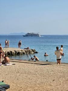 un gruppo di persone su una spiaggia con una barca in acqua di Apartments Lora a Vir (Puntadura)