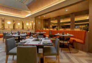 Sonesta Hotel Miraflores في ليما: مطعم يحتوي على طاولات وكراسي في الغرفة +20 صورة