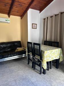 Un comedor con una mesa y sillas y un sofá. en Bungalows El Amanecer, en Colón