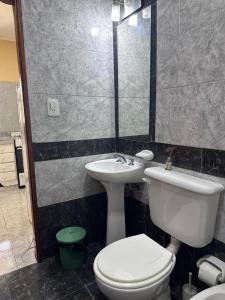 Un baño con un inodoro blanco y un lavabo. en Bungalows El Amanecer, en Colón