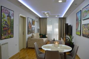 a living room with a table and a couch at Su inn apartman in Subotica