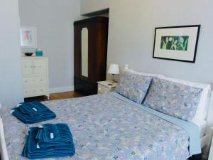 a bedroom with a bed with blue towels on it at Holmlea Cottage in Freuchie
