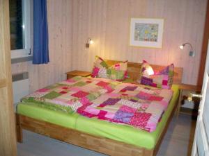 a bedroom with a bed with a quilt on it at Ferienhaus im skandinavischen Stil in Granzow
