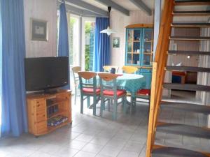 a living room with a table and chairs and a television at Ferienhaus im skandinavischen Stil in Granzow