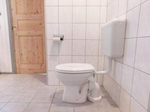 a white toilet in a bathroom with a door at Ferienhaus im skandinavischen Stil in Granzow +16 photos