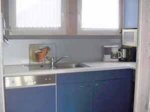 a kitchen with a sink and a microwave at Ferienhaus im skandinavischen Stil in Granzow