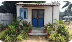 a small house with a blue door and some plants at Mystic Resort Dublagadi in Balasore