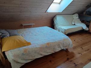 Un dormitorio con una cama con un osito de peluche sentado en una silla. en Chambre calme et verdure, en Arlay