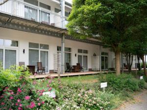a building with chairs and flowers in a yard at Apartment für den perfekten Urlaub in Granzow